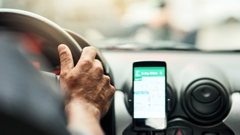 Smartphone sur un support dans une voiture avec l'app Google Map ouverte.